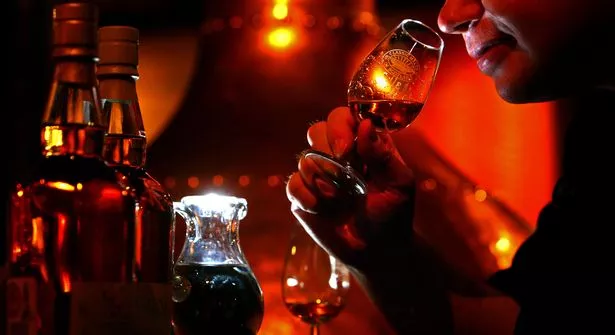 Andrew Kirk, a malt advocate, noses a glass of whisky at Glenkinchie distillery