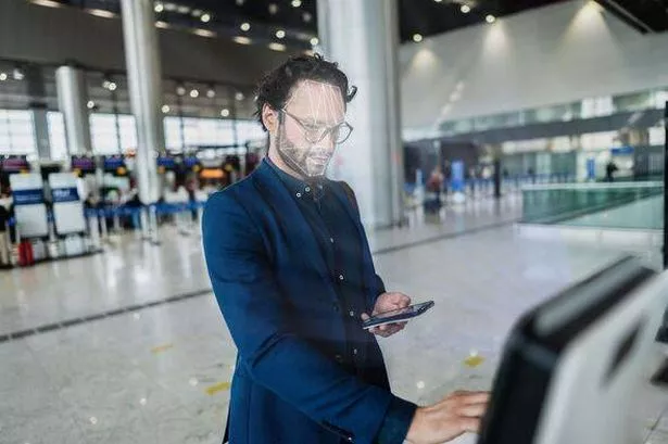 Mature businessman using facial recognition technology in a self-service check-in machine at the airport