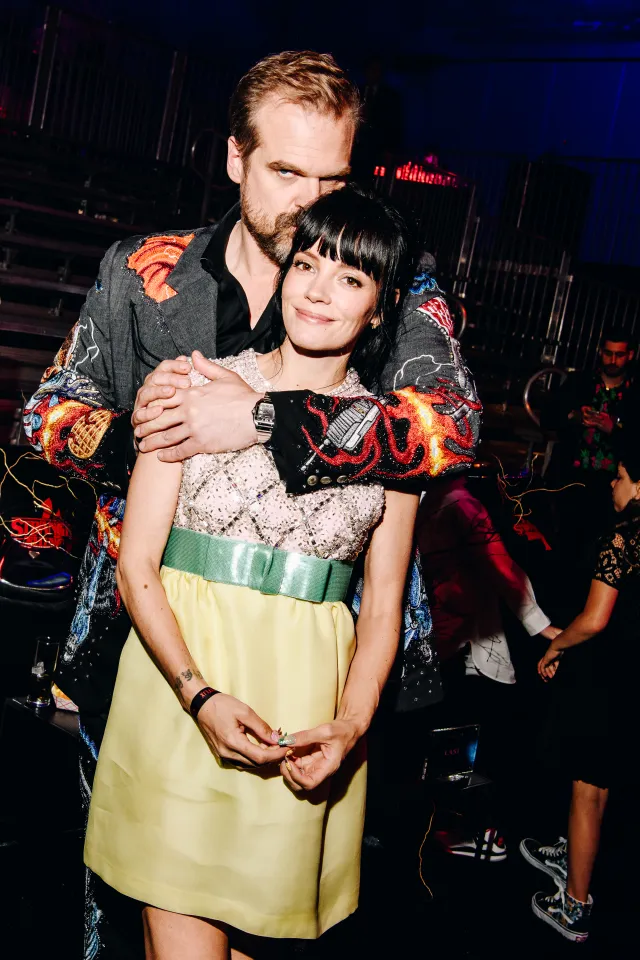 David Harbour and Lily Allen in a dark venue.