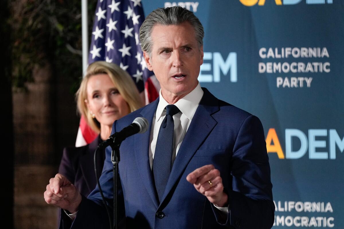 California Gov. Gavin Newsom speaks as he stands with first partner Jennifer Siebel Newsom 